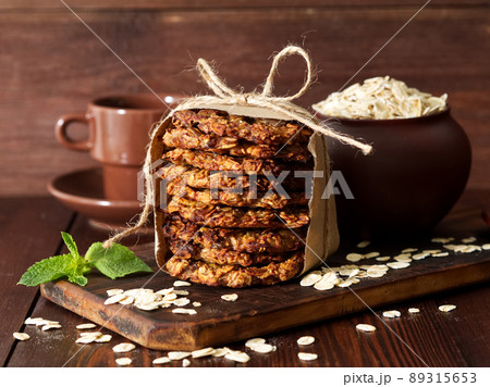 Homemade oatmeal cookies with banana, oats, nuts, eggs and flour free on table, side view. Homemade oatmeal cookies with banana, oats, nuts, eggs and flour free on table, side view. 89315653