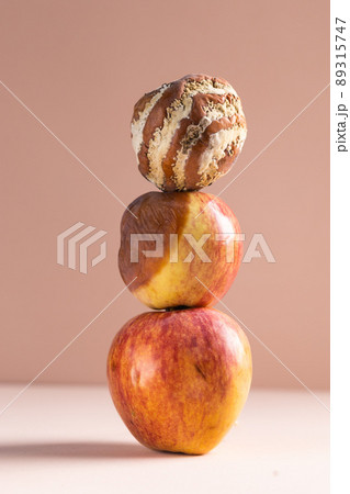 Apple with mold and fresh apple on beige background - mold growth and food spoilage concept. Copy space and place for advertising Apple with mold and fresh apple on beige background - mold growth and food spoilage concept. Copy space and place for advertising 89315747