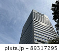 見上げた都会の高層オフィスビルと青空 89317295