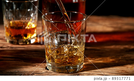 Detail of pouring whisky into glass. Detail of pouring whisky into glass. 89317771