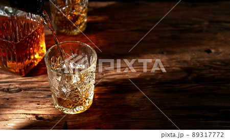 Detail of pouring whisky into glass. Detail of pouring whisky into glass. 89317772