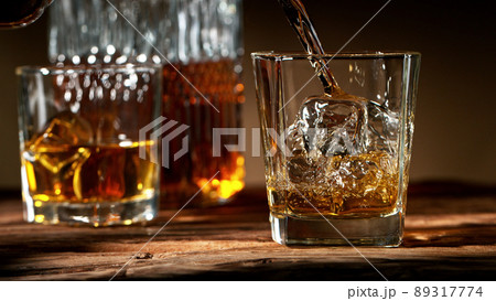 Detail of pouring whisky into glass. Detail of pouring whisky into glass. 89317774