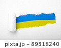Ukrainian blue and yellow flag in the hole in paper 89318240