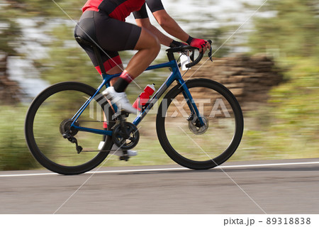 Road bike cyclist man cycling, athlete on a race cycle. Panning technique used Road bike cyclist man cycling, athlete on a race cycle. Panning technique used 89318838
