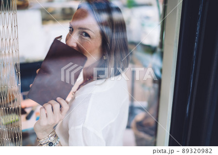 Pretty woman poet with personal notepad shy while posing indoors Pretty woman poet with personal notepad shy while posing indoors 89320982