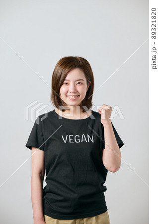 ヴィーガンのTシャツを着てガッツポーズをする若い女性 89321820
