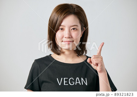 ヴィーガンのTシャツを着て人差し指をたてる若い女性 89321823