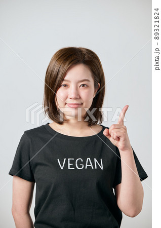 ヴィーガンのTシャツを着て人差し指をたてる若い女性 89321824
