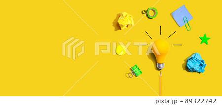 Brainstorming concept with a light bulb and school supplies - Flat lay Brainstorming concept with a light bulb and school supplies - Flat lay 89322742