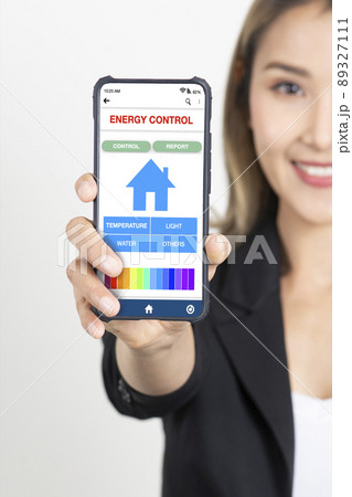 Business woman in black suit showing mobile electricity and power control application on smartphone on white background. Business woman in black suit showing mobile electricity and power control application on smartphone on white background. 89327111