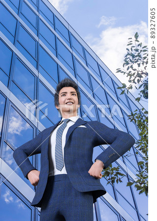 ビル街で腰に手を当て、笑顔で遠くを見つめ、仕事の成功を願うビジネスマン 89327605