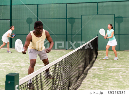 Positive young adult people playing paddle tennis 89328585