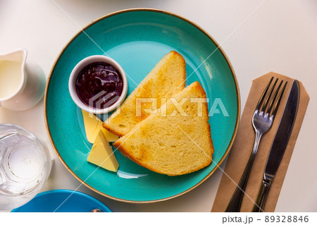 Golden toasts jam and cheese on table. Delicious breakfast 89328846