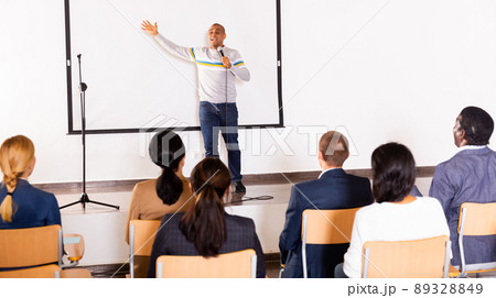 Male coach giving speech at conference hall 89328849