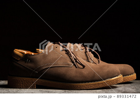 Side view of brown shoes with laces on a black background Side view of brown shoes with laces on a black background 89331472