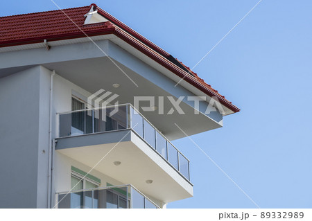 An open balcony located on the top floor of a residential building. An open balcony located on the top floor of a residential building. 89332989