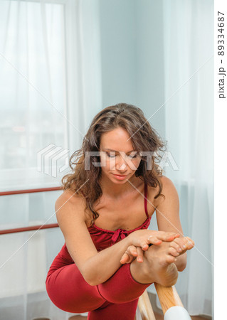 A choreographer in a red jumpsuit is engaged near the machine, in the choreographic hall. A choreographer in a red jumpsuit is engaged near the machine, in the choreographic hall. 89334687