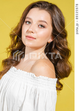 Beautiful bright woman in the studio on a yellow Beautiful bright woman in the studio on a yellow 89335978