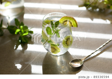 Kiwi mojito cocktail or caipirinha drink recipes with mint and ice in glasses close up. Summer cold drink kiwi lemonade 89336594