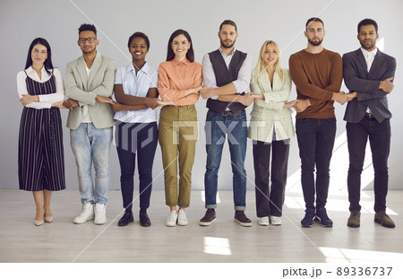 Team of diverse colleagues stand holding hands demonstrating each other's unity and support. 89336737