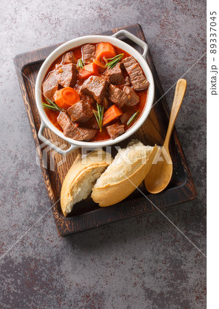 Daube Provencal French stew beef with vegetables is slow simmered to tenderness closeup in the wooden tray. Vertical top view Daube Provencal French stew beef with vegetables is slow simmered to tenderness closeup in the wooden tray. Vertical top view 89337045