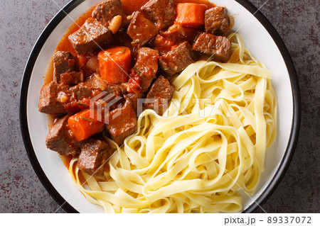 Provencal Beef Stew Daube served with noodles closeup in the plate. Horizontal top view 89337072
