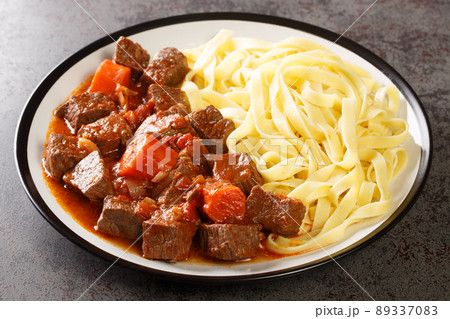 Provencal Beef Stew Daube served with noodles closeup in the plate. Horizontal 89337083