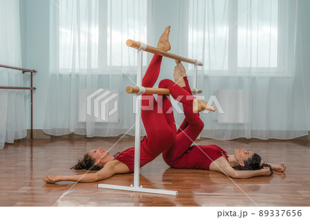 I train with a friend. Two young women train together in a bright training room near a choreographic machine. 89337656
