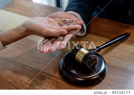 Judge gavel and two golden marriage ring, Contract decree of divorce (dissolution or cancellation) of marriage, husband and wife during divorce process and signing of divorce contract 89338175