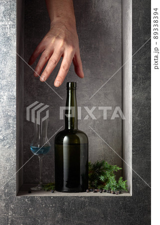 Hand reach for a vintage bottle of gin. Hand reach for a vintage bottle of gin. 89338394