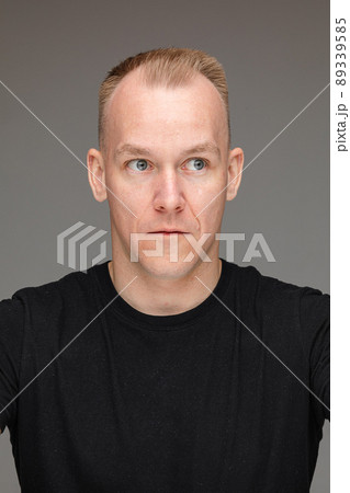 Man with wide eyes looking away. 89339585