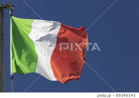 Italian flag blowing in the wind in the blue sky 89340343