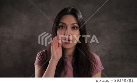 Young woman whispers something to the camera 89340783