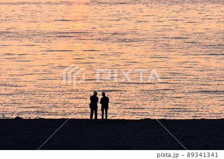 大阪府の二色浜で夕日を眺めるカップル 大阪府の二色浜で夕日を眺めるカップル 89341341