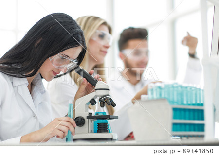 female scientist uses a microscope for research in a laboratory 89341850