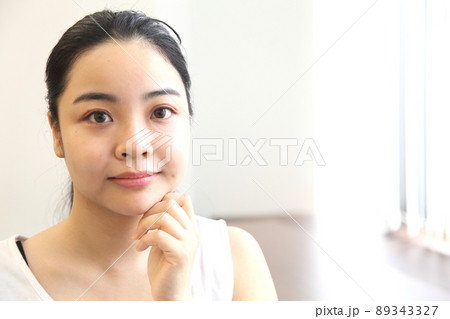 頬に手を触れる女性の顔 頬に手を触れる女性の顔 89343327