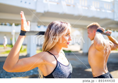 Young couple in sports outfit doing morning workout outdoors in hot summer Young couple in sports outfit doing morning workout outdoors in hot summer 89344430