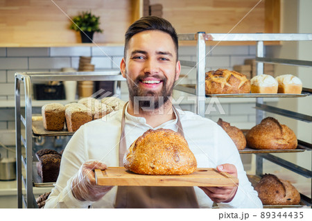 Handsome baker in uniform at the manufacturing small business owner concept Handsome baker in uniform at the manufacturing small business owner concept 89344435