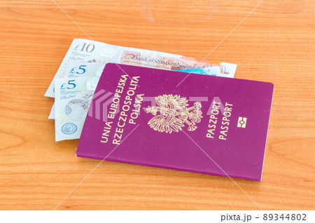 Polish passport with Pound sterling money bill on wooden table. Polish passport with Pound sterling money bill on wooden table. 89344802
