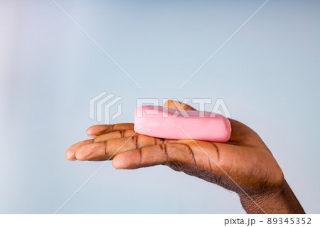 African man holds and show a piece of wet soap in studio white background African man holds and show a piece of wet soap in studio white background 89345352