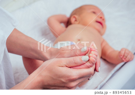 woman making foot massage to her little child close up woman making foot massage to her little child close up 89345653
