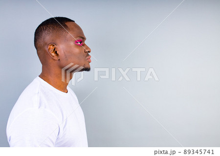 afro american man in white t-shirt casual style with pink eyeshadow and lipstick crossdressing in fashion show studio background 89345741