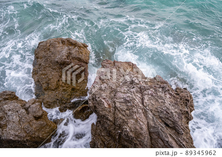 The huge rocks in the sea, being hit by the strong waves 89345962