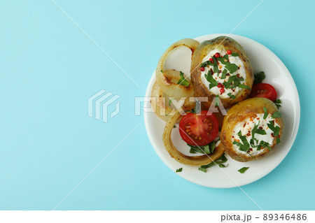 Plate with baked potato on blue background Plate with baked potato on blue background 89346486
