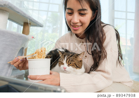 Young Asian woman working from home with her cat 89347938