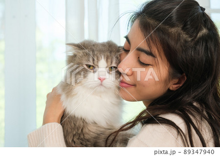Young Asian woman working from home with her cat 89347940