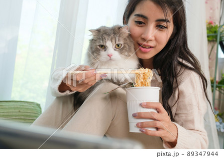 Young Asian woman working from home with her cat 89347944