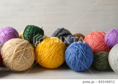 Balls of yarn on white wooden background 89348652