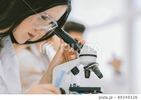 close up.the scientist looks into the microscope in the laborat close up.the scientist looks into the microscope in the laborat 89349326
