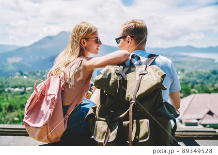 Happy couple with backpacks looking at each other 89349528